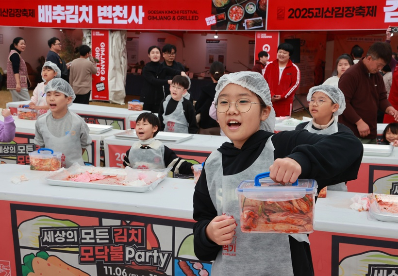 8일 괴산유기농엑스포 광장에서 열린 ‘2025 괴산김장축제’ 어린이 김장체험에서 참가한 어린이가 자신이 만든 김치통을 들어 보이며 환하게 웃고 있다.jpg